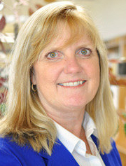 Photo of Debbie Hoekstra. Debbie has shoulder length blonde hair. She wears a bright blue blazer over a white dress shirt.